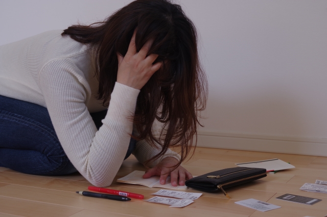 お金を手に頭を抱える。西東京市で債務整理の無料相談ができます